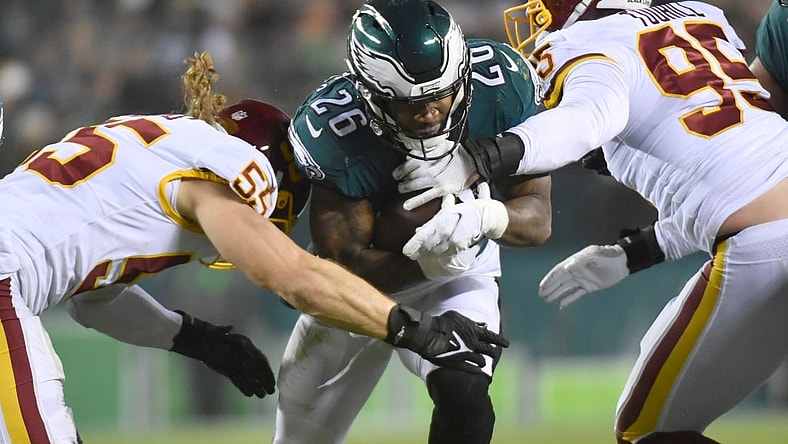Dec 21, 2021; Philadelphia, Pennsylvania, USA; Philadelphia Eagles running back Miles Sanders (26) his tackled by Washington Football Team outside linebacker Cole Holcomb (55) and defensive end Casey Toohill (95) during the second quarter at Lincoln Financial Field. Mandatory Credit: Eric Hartline-USA TODAY Sports