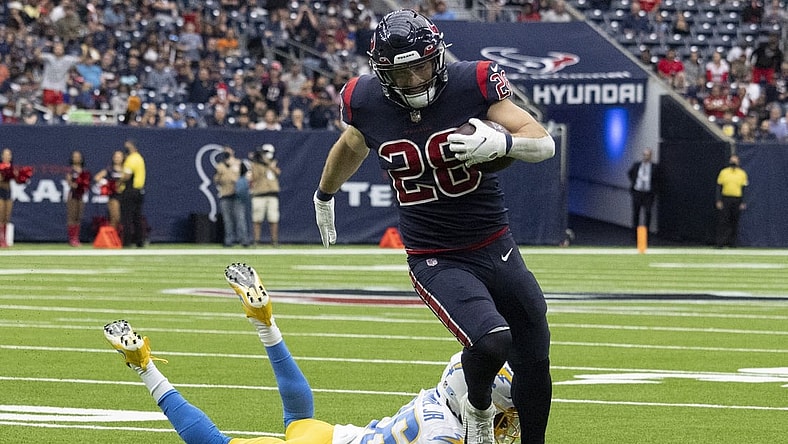 Dec 26, 2021; Houston, Texas, USA;  Houston Texans running back Rex Burkhead (28) runs for a touchdown against Los Angeles Chargers defensive back Trey Marshall (36) in the first quarter at NRG Stadium. Mandatory Credit: Thomas Shea-USA TODAY Sports