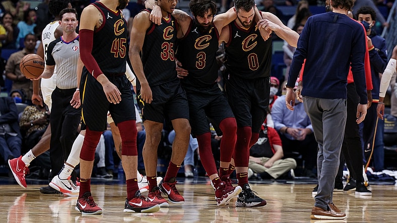 Dec 28, 2021; New Orleans, Louisiana, USA; Cleveland Cavaliers guard Ricky Rubio (3) is helped off the court by forward Kevin Love (0) and forward Isaac Okoro (35) after injuring his ankle against New Orleans Pelicans forward Herbert Jones (5) during the second half at Smoothie King Center. Mandatory Credit: Stephen Lew-USA TODAY Sports