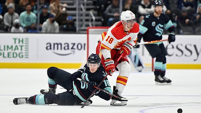 Dec 30, 2021; Seattle, Washington, USA; Seattle Kraken left wing Jared McCann (16) and Calgary Flames center Tyler Pitlick (18) fight for the puck during the first period at Climate Pledge Arena. Mandatory Credit: Steven Bisig-USA TODAY Sports
