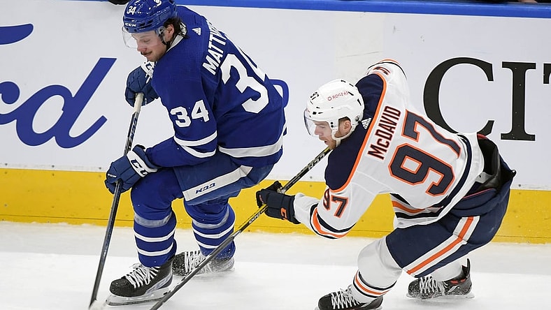 Mar 29, 2021; Toronto, Ontario, CAN; Edmonton Oilers forward Connor McDavid (97) takes the puck away from Toronto Maple Leafs forward Auston Matthews (34) in the first period at Scotiabank Arena. Mandatory Credit: Dan Hamilton-USA TODAY Sports