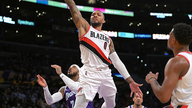 Dec 31, 2021; Los Angeles, California, USA; Portland Trail Blazers guard Damian Lillard (0) goes to the basket past Los Angeles Lakers forward Carmelo Anthony (7) in the first half at Crypto.com Arena. Mandatory Credit: Jayne Kamin-Oncea-USA TODAY Sports