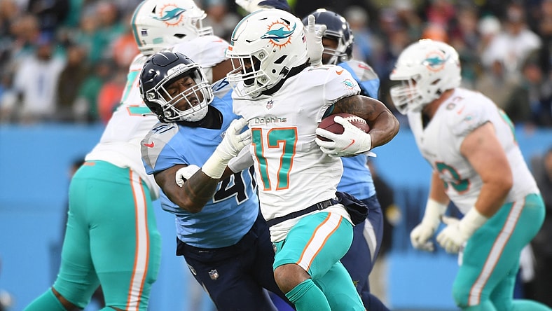 Jan 2, 2022; Nashville, Tennessee, USA; Miami Dolphins wide receiver Jaylen Waddle (17) fights off a tackle attempt from Tennessee Titans outside linebacker Zach Cunningham (41) during the first half at Nissan Stadium. Mandatory Credit: Christopher Hanewinckel-USA TODAY Sports
