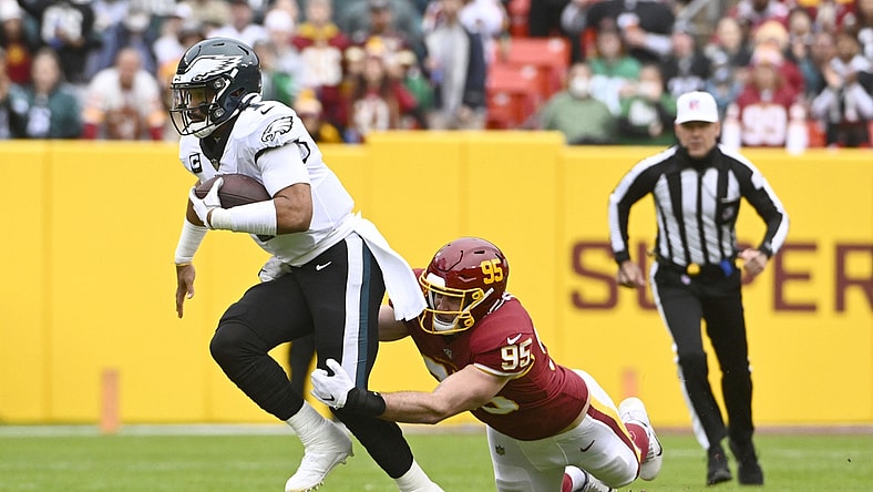 Jan 2, 2022; Landover, Maryland, USA; Philadelphia Eagles quarterback Jalen Hurts (1) scrambles as Washington Football Team defensive end Casey Toohill (95) defends during the first half at FedExField. Mandatory Credit: Brad Mills-USA TODAY Sports