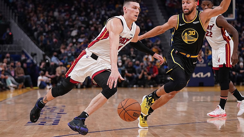 Jan 3, 2022; San Francisco, California, USA; Miami Heat guard Tyler Herro (14) dribbles past Golden State Warriors guard Stephen Curry (30) in the second quarter at the Chase Center. Mandatory Credit: Cary Edmondson-USA TODAY Sports