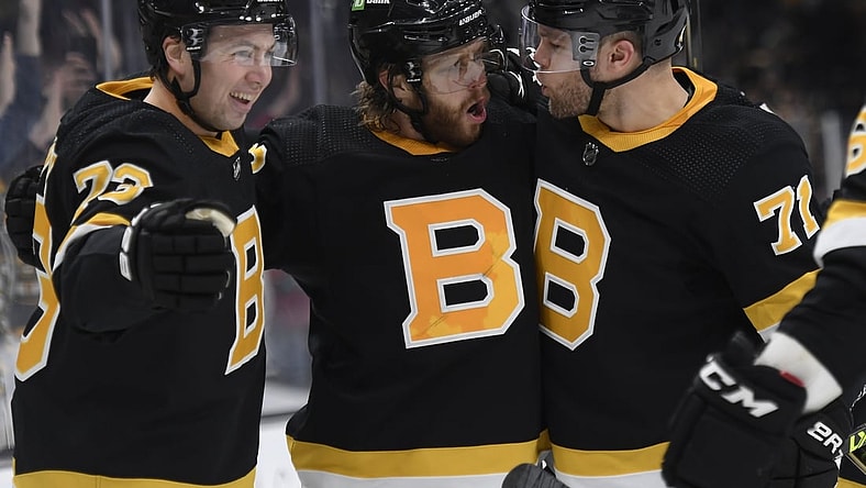 Jan 4, 2022; Boston, Massachusetts, USA;  Boston Bruins right wing David Pastrnak (88) reacts with defenseman Charlie McAvoy (73) and left wing Taylor Hall (71) after scoring a goal during the third period against the New Jersey Devils at TD Garden. Mandatory Credit: Bob DeChiara-USA TODAY Sports