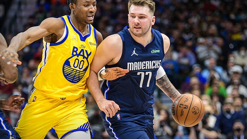 Jan 5, 2022; Dallas, Texas, USA; Golden State Warriors forward Jonathan Kuminga (00) guards Dallas Mavericks guard Luka Doncic (77) during the second quarter at the American Airlines Center. Mandatory Credit: Jerome Miron-USA TODAY Sports
