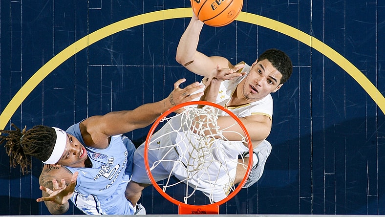Jan 5, 2022; South Bend, Indiana, USA; Notre Dame Fighting Irish forward Paul Atkinson Jr. (20) shoots as North Carolina Tar Heels forward Armando Bacot (5) defends in the second half at the Purcell Pavilion. Mandatory Credit: Matt Cashore-USA TODAY Sports