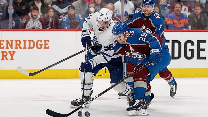 Jan 8, 2022; Denver, Colorado, USA; Toronto Maple Leafs left wing Michael Bunting (58) and Colorado Avalanche center Nathan MacKinnon (29) battle for the puck in the first period at Ball Arena. Mandatory Credit: Isaiah J. Downing-USA TODAY Sports