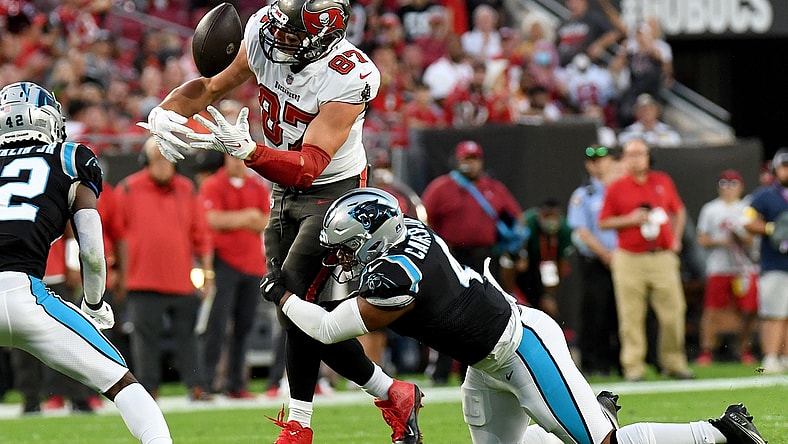 Jan 9, 2022; Tampa, Florida, USA;  Tampa Bay Buccaneers tight end Rob Gronkowski (87) juggles the ball as Carolina Panthers linebacker Jermaine Carter Jr. (4) attempts to make the tackle  in the first half at Raymond James Stadium. Mandatory Credit: Jonathan Dyer-USA TODAY Sports