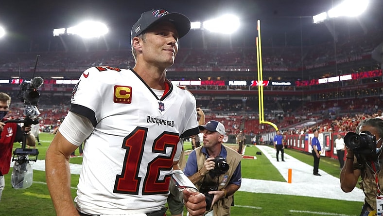 Jan 9, 2022; Tampa, Florida, USA;Tampa Bay Buccaneers quarterback Tom Brady (12) smiles as he runs off the field after they beat the against the Carolina Panthers at Raymond James Stadium. Mandatory Credit: Kim Klement-USA TODAY Sports