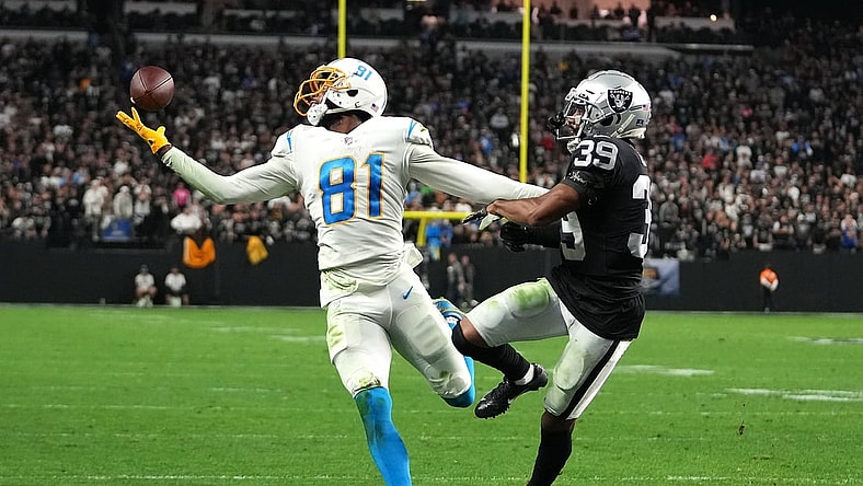 Jan 9, 2022; Paradise, Nevada, USA; Los Angeles Chargers wide receiver Mike Williams (81) reaches for a pass as Las Vegas Raiders cornerback Nate Hobbs (39) defends during an overtime period at Allegiant Stadium. Mandatory Credit: Stephen R. Sylvanie-USA TODAY Sports