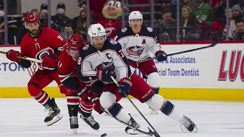 Jan 13, 2022; Raleigh, North Carolina, USA; Columbus Blue Jackets center Boone Jenner (38) handles the puck against Carolina Hurricanes right wing Andrei Svechnikov (37) during the first period at PNC Arena. Mandatory Credit: James Guillory-USA TODAY Sports