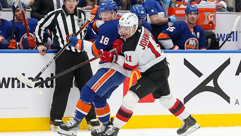 Jan 13, 2022; Elmont, New York, USA; New York Islanders left wing Anthony Beauvillier (18) and New Jersey Devils left wing Andreas Johnsson (11) battle for the puck during the first period at UBS Arena. Mandatory Credit: Tom Horak-USA TODAY Sports