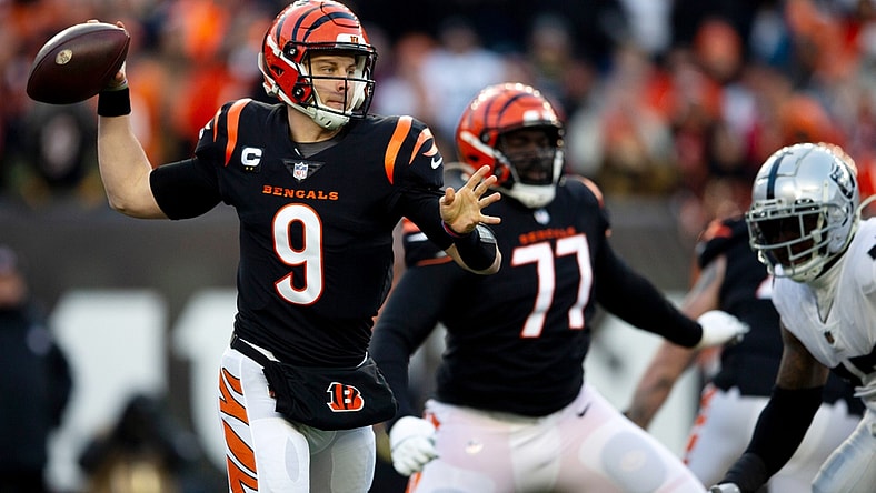 Jan 15, 2022; Cincinnati, OH, USA;  Cincinnati Bengals quarterback Joe Burrow (9) throws for a first down in the first half the AFC wild card game between the Cincinnati Bengals and the Las Vegas Raiders on Saturday, Jan. 15, 2022, at Paul Brown Stadium in Cincinnati. Mandatory Credit: Albert Cesare-USA TODAY Sports
