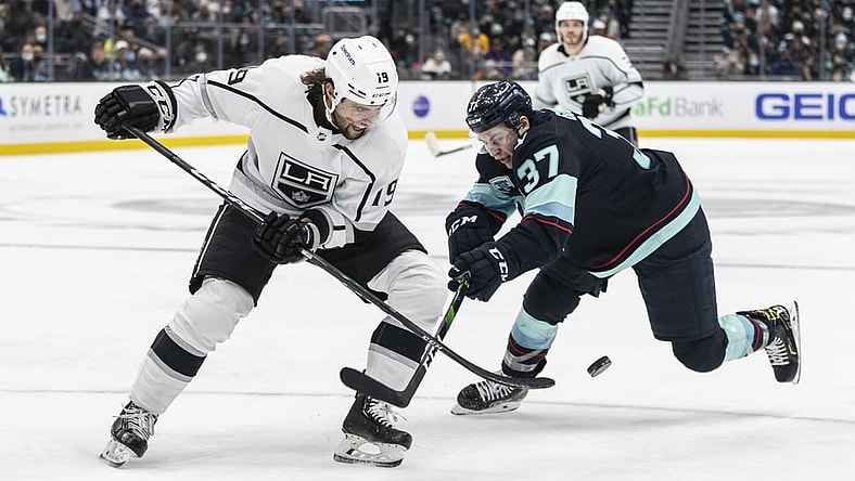 Jan 15, 2022; Seattle, Washington, USA;  Los Angeles Kings left wing Alex Iafallo (19) and Seattle Kraken center Yanni Gourde(37) battle for the puck during the second period at Climate Pledge Arena. Mandatory Credit: Stephen Brashear-USA TODAY Sports