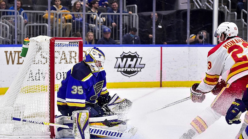 Jan 27, 2022; St. Louis, Missouri, USA;  St. Louis Blues goaltender Ville Husso (35) defends the net against Calgary Flames center Sean Monahan (23) during the first period at Enterprise Center. Mandatory Credit: Jeff Curry-USA TODAY Sports