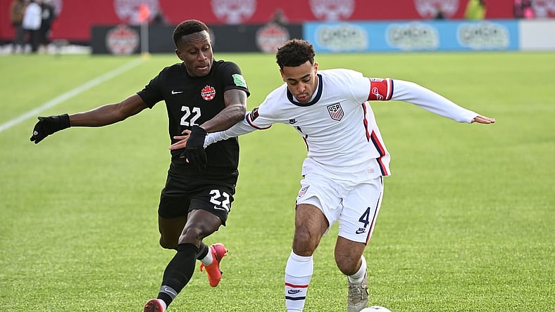 Jan 30, 2022; Hamilton, Ontario, CAN;   Canada defender Richie Laryea (22) battles for the ball with United States midfielder Tyler Adams (4) during a CONCACAF FIFA World Cup Qualifier soccer match at Tim Hortons Field. Mandatory Credit: Dan Hamilton-USA TODAY Sports