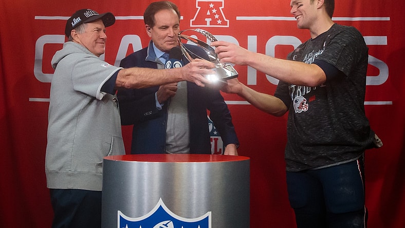 Jan 20, 2019; Kansas City, MO, USA; CBS sportscaster Jim Nantz (center) looks on as New England Patriots head coach Bill Belichick hands the trophy to quarterback Tom Brady (12) after their win over the Kansas City Chiefs in the AFC Championship game at Arrowhead Stadium. Mandatory Credit: Mark J. Rebilas-USA TODAY Sports