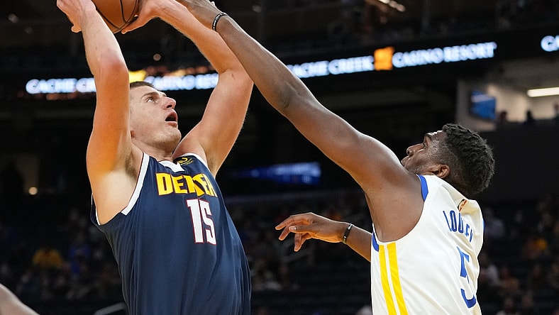 October 6, 2021; San Francisco, California, USA; Denver Nuggets center Nikola Jokic (15) shoots the basketball against Golden State Warriors center Kevon Looney (5) during the first quarter at Chase Center. Mandatory Credit: Kyle Terada-USA TODAY Sports