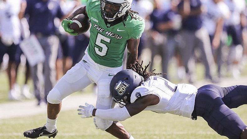 Oct 9, 2021; Huntington, West Virginia, USA; Marshall Thundering Herd running back Sheldon Evans (5) runs the ball and shakes a tackle from Old Dominion Monarchs safety R'Tarriun Johnson (21) during the second quarter at Joan C. Edwards Stadium. Mandatory Credit: Ben Queen-USA TODAY Sports