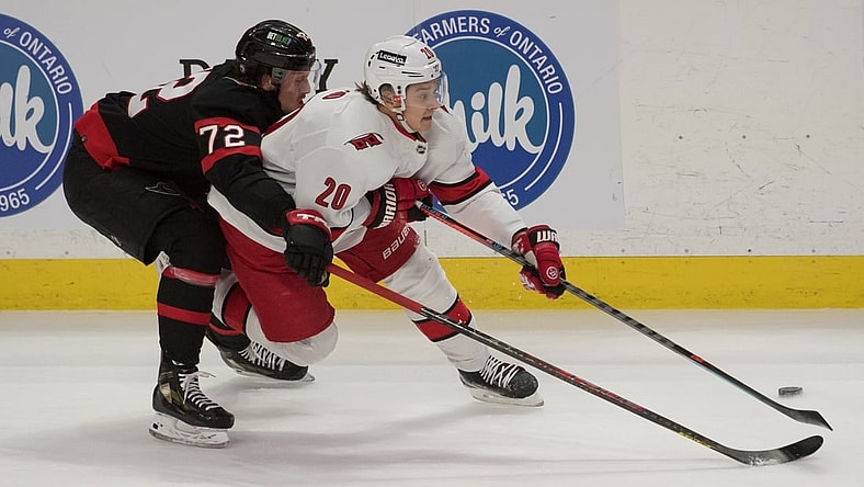Jan 27, 2022; Ottawa, Ontario, CAN; Ottawa Senators defenseman Thomas Chabot (72) battles with Carolina Hurricanes center Sebastian Aho (20) for control of the puck in the third period at the Canadian Tire Centre. Mandatory Credit: Marc DesRosiers-USA TODAY Sports