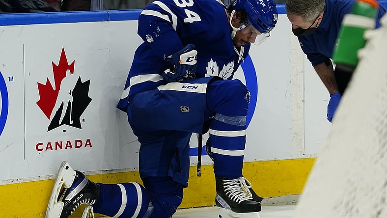 Feb 7, 2022; Toronto, Ontario, CAN; A Toronto Maple Leafs trainer checks on an injured forward Auston Matthews (34) during the third period against the Carolina Hurricanes at Scotiabank Arena. Mandatory Credit: John E. Sokolowski-USA TODAY Sports
