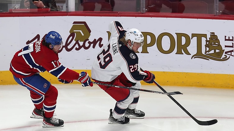 Feb 12, 2022; Montreal, Quebec, CAN; Columbus Blue Jackets left wing Patrik Laine (29) plays the puck against Montreal Canadiens right wing Josh Anderson (17) during the first period at Bell Centre. Mandatory Credit: Jean-Yves Ahern-USA TODAY Sports
