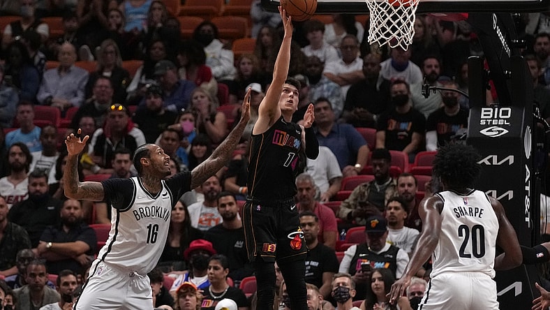 Feb 12, 2022; Miami, Florida, USA; Miami Heat guard Tyler Herro (14) shoots the ball around Brooklyn Nets forward James Johnson (16) during the first half at FTX Arena. Mandatory Credit: Jasen Vinlove-USA TODAY Sports