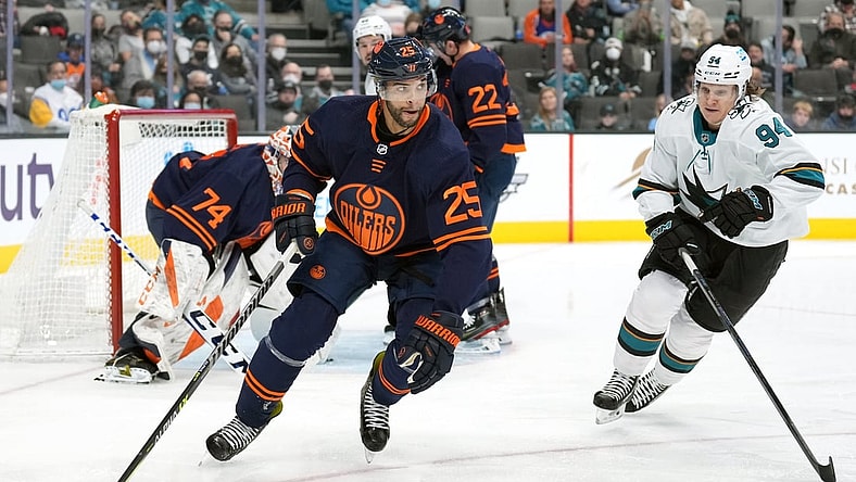 Feb 14, 2022; San Jose, California, USA; Edmonton Oilers defenseman Darnell Nurse (25) skates with the puck while being pursued by San Jose Sharks left wing Alexander Barabanov (94) during the second period at SAP Center at San Jose. Mandatory Credit: Darren Yamashita-USA TODAY Sports