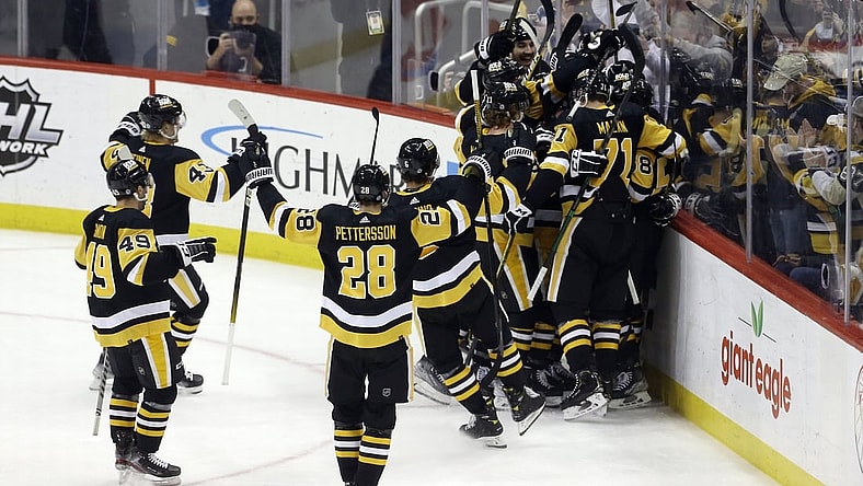 Feb 15, 2022; Pittsburgh, Pennsylvania, USA;  Pittsburgh Penguins center Sidney Crosby (hiden) is mobbed by teammates after Crosby scored his 500th career NHL goal against the Philadelphia Flyers during the first period at PPG Paints Arena. Mandatory Credit: Charles LeClaire-USA TODAY Sports