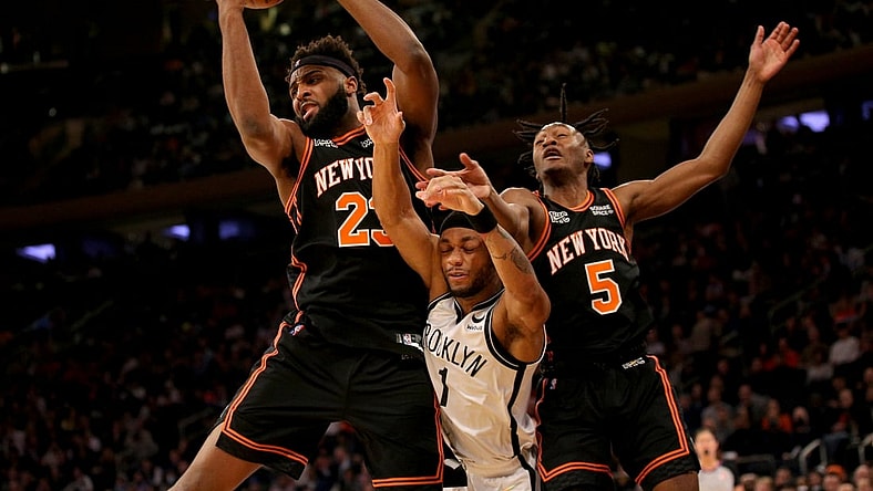 Feb 16, 2022; New York, New York, USA; New York Knicks center Mitchell Robinson (23) grabs a rebound against Brooklyn Nets forward Bruce Brown (1) in front of Knicks guard Immanuel Quickley (5) during the second quarter at Madison Square Garden. Mandatory Credit: Brad Penner-USA TODAY Sports