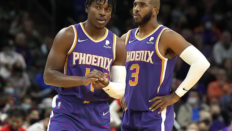 Feb 16, 2022; Phoenix, Arizona, USA; Phoenix Suns guard Aaron Holiday (4) and guard Chris Paul (3) talk during a time-out against the Houston Rockets at Footprint Center. Mandatory Credit: Rick Scuteri-USA TODAY Sports