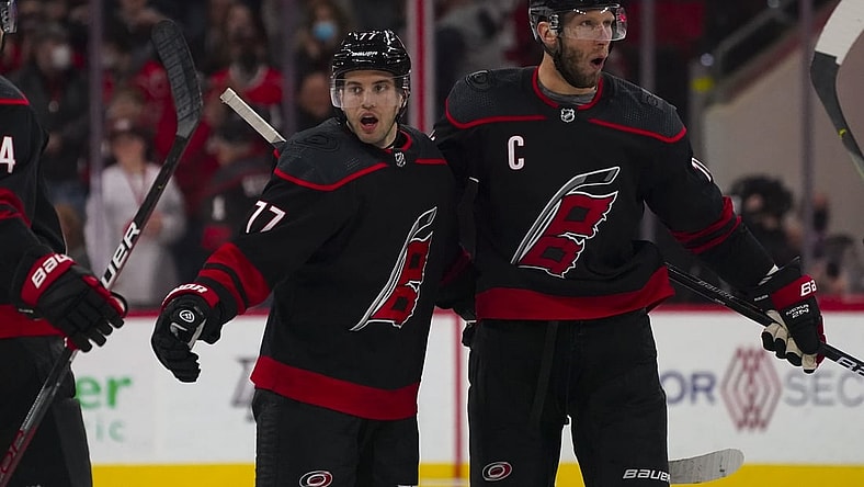 Feb 16, 2022; Raleigh, North Carolina, USA; Carolina Hurricanes defenseman Tony DeAngelo (77) is congratulated by center Jordan Staal (11) after his goal against the Florida Panthers during the third period at PNC Arena. Mandatory Credit: James Guillory-USA TODAY Sports
