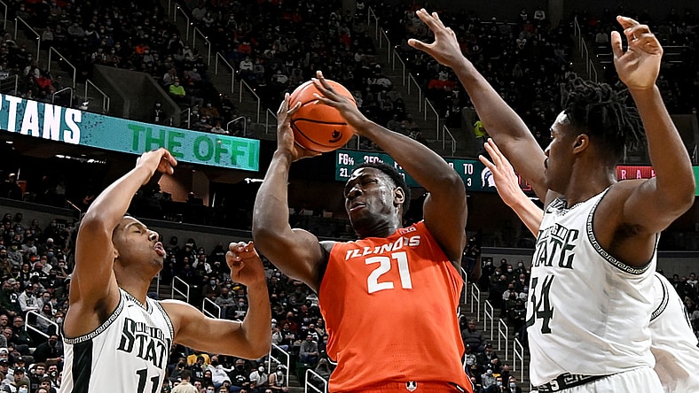 Feb 19, 2022; East Lansing, Michigan, USA; Illinois Fighting Illini center Kofi Cockburn (21) grabs a rebound in the first half against Michigan State Spartans guard A.J. Hoggard (11) and forward Julius Marble II (34) at Jack Breslin Student Events Center. Mandatory Credit: Dale Young-USA TODAY Sports