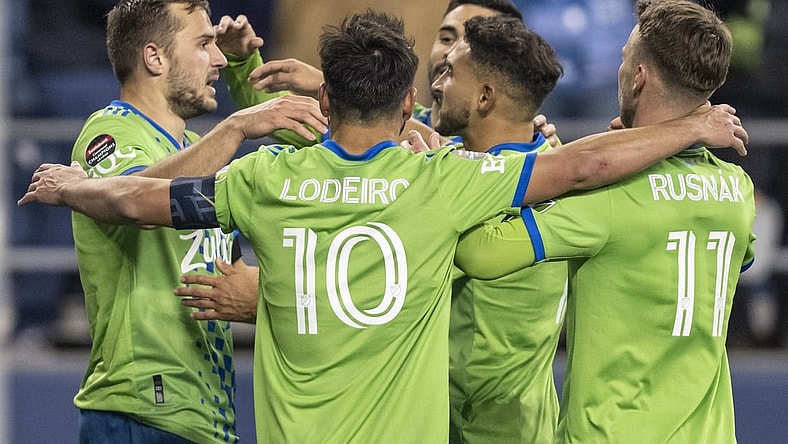 Feb 24, 2022; Seattle, WA, USA; Seattle Sounders FC including, from left, forward Jordan Morris (13), midfielder Nicolas Lodeiro (10), midfielder Cristian Roldan (7)] and midfielder Albert Rusnak (11) celebrate a goal against FC Motagua during the second half at Lumen Field. Mandatory Credit: Stephen Brashear-USA TODAY Sports
