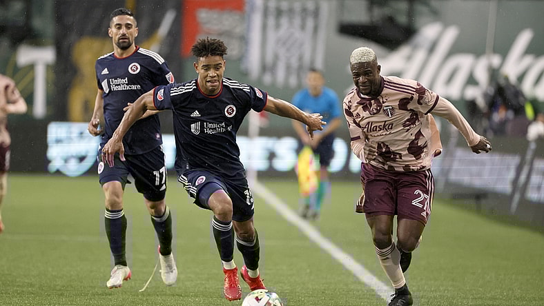 Feb 26, 2022; Portland, Oregon, USA; Portland Timbers forward Dairon Asprilla (27) dribbles the ball against New England Revolution defender Brandon Bye (15) during the first half at Providence Park. Mandatory Credit: Soobum Im-USA TODAY Sports