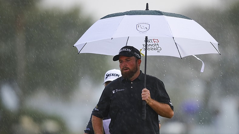 Feb 27, 2022; Palm Beach Gardens, Florida, USA; Shane Lowry holds an umbrella on the 18th green while it rains during the final round of The Honda Classic golf tournament. Mandatory Credit: Sam Navarro-USA TODAY Sports