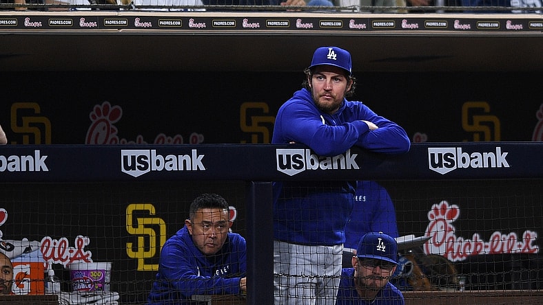 Jun 22, 2021; San Diego, California, USA; Los Angeles Dodgers starting pitcher Trevor Bauer (top) looks on from the dugout during the fifth inning against the San Diego Padres at Petco Park. Mandatory Credit: Orlando Ramirez-USA TODAY Sports