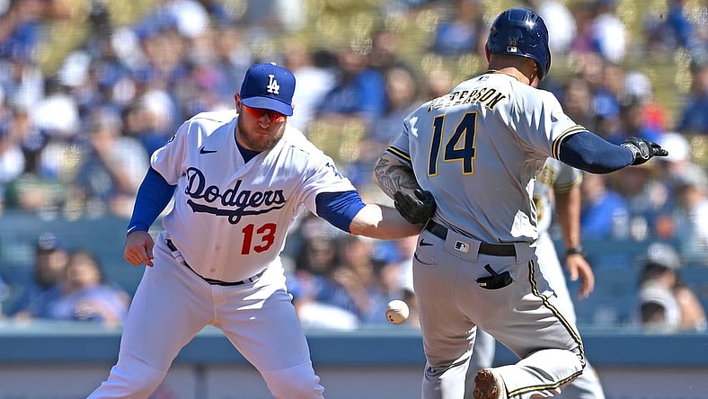 Oct 3, 2021; Los Angeles, California, USA;  Los Angeles Dodgers first baseman Max Muncy (13) makes a tag against Milwaukee Brewers second baseman Jace Peterson (14) on a throw from Dodgers shortstop Trea Turner (not pictured) in the third inning at Dodger Stadium. Muncy left the game with an apparent injury to his left arm. Mandatory Credit: Jayne Kamin-Oncea-USA TODAY Sports