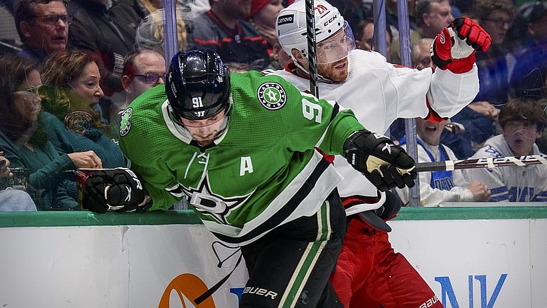 Nov 30, 2021; Dallas, Texas, USA; Dallas Stars center Tyler Seguin (91) checks Carolina Hurricanes defenseman Ian Cole (28) during the second period at the American Airlines Center. Mandatory Credit: Jerome Miron-USA TODAY Sports