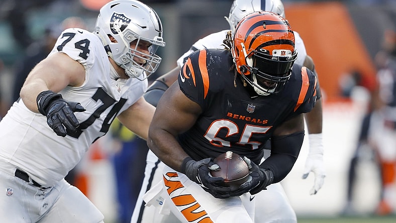 Jan 15, 2022; Cincinnati, Ohio, USA; Cincinnati Bengals defensive tackle Larry Ogunjobi (65) picks up the fumble as Las Vegas Raiders offensive tackle Kolton Miller (74) goes for the tackle during the first quarter in an AFC Wild Card playoff football game at Paul Brown Stadium. Mandatory Credit: Joseph Maiorana-USA TODAY Sports