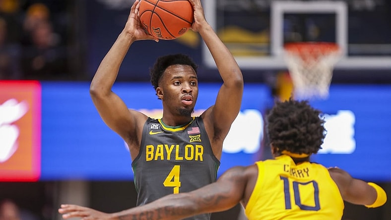 Jan 18, 2022; Morgantown, West Virginia, USA; Baylor Bears guard LJ Cryer (4) looks to pass while defended by West Virginia Mountaineers guard Malik Curry (10) during the first half at WVU Coliseum. Mandatory Credit: Ben Queen-USA TODAY Sports
