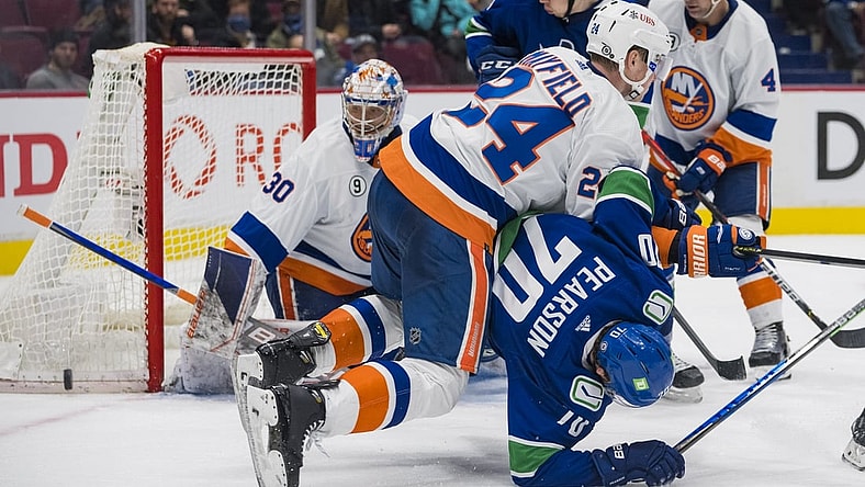 Feb 9, 2022; Vancouver, British Columbia, CAN; New York Islanders defenseman Scott Mayfield (24) checks Vancouver Canucks forward Tanner Pearson (70) in the third period at Rogers Arena. New York won 6-3. Mandatory Credit: Bob Frid-USA TODAY Sports