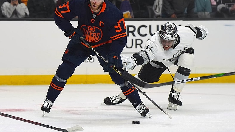 Feb 15, 2022; Los Angeles, California, USA; Edmonton Oilers center Connor McDavid (97) and LA Kings center Anze Kopitar (11) battle for the puck in the first period at Crypto.com Arena. Mandatory Credit: Kirby Lee-USA TODAY Sports