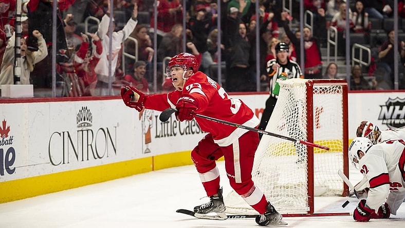 Mar 1, 2022; Detroit, Michigan, USA; Detroit Red Wings left wing Lucas Raymond (23) scores the game winning goal during overtime against Carolina Hurricanes goaltender Antti Raanta (32) at Little Caesars Arena. Mandatory Credit: Raj Mehta-USA TODAY Sports