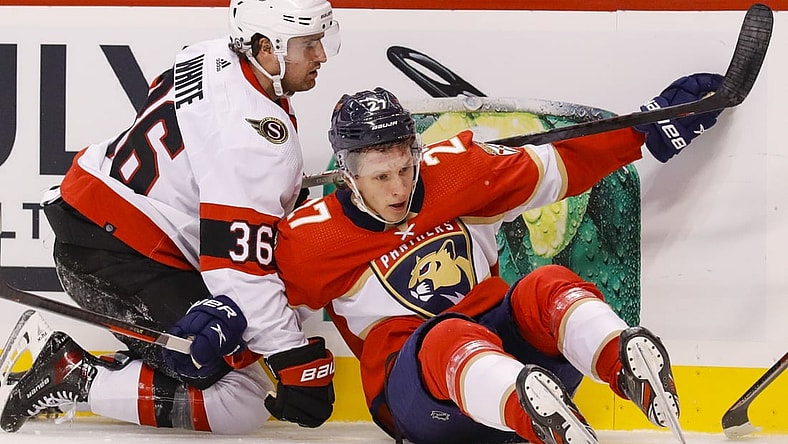 Mar 3, 2022; Sunrise, Florida, USA; Ottawa Senators center Colin White (36) and Florida Panthers center Eetu Luostarinen (27) collide against the boards during the second period at FLA Live Arena. Mandatory Credit: Sam Navarro-USA TODAY Sports