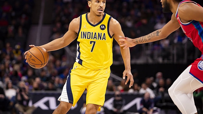 Mar 4, 2022; Detroit, Michigan, USA; Indiana Pacers guard Malcolm Brogdon (7) gets defended by Detroit Pistons forward Marvin Bagley III (35) during the second quarter at Little Caesars Arena. Mandatory Credit: Raj Mehta-USA TODAY Sports