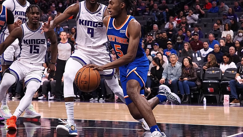Mar 7, 2022; Sacramento, California, USA; New York Knicks guard Immanuel Quickley (5) drives along the baseline against Sacramento Kings guard Davion Mitchell (15) and guard Justin Holiday (9) during the second quarter at Golden 1 Center. Mandatory Credit: Kelley L Cox-USA TODAY Sports