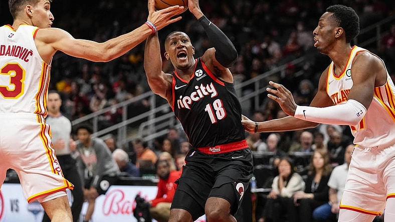 Mar 14, 2022; Atlanta, Georgia, USA; Portland Trail Blazers guard Kris Dunn (18) drives to the basket against Atlanta Hawks guard Bogdan Bogdanovic (13) and forward Onyeka Okongwu (17) during the first quarter at State Farm Arena. Mandatory Credit: Dale Zanine-USA TODAY Sports